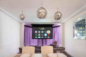 a dining room with purple curtains and a screen at SPACESHIP UNIT2 122Tb in Tokyo