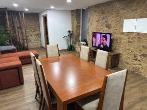a dining room with a wooden table and a tv at Casa do Canastro in Sever do Vouga