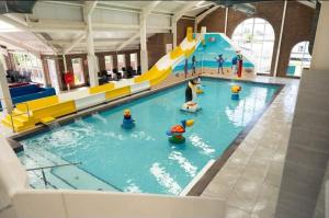a indoor swimming pool with a water slide at TH Holidays in Meliden