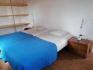 a bedroom with a blue bed and a night stand at Casa Atlântico in Odeceixe