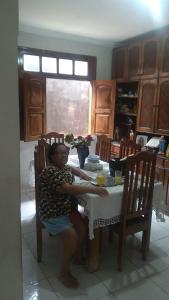a woman sitting at a table in a kitchen at Casa santa Marta in Belém +8 photos
