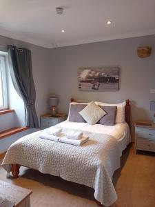 a bedroom with a bed with two towels on it at St Andrews House B&B in Lyme Regis +51 photos