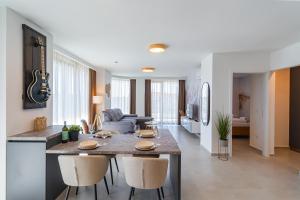 a kitchen and living room with a table and chairs at MyFlat Wave Beach Apartments in Siófok