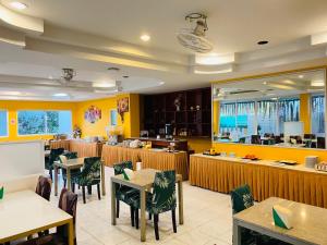 a restaurant with tables and chairs and yellow walls at Baan Chanchay Hua Hin in Hua Hin