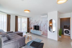 a living room with a couch and a tv at MyFlat Wave Beach Apartments in Siófok