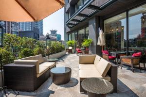 a patio area with chairs, tables and umbrellas at Lacle Hotel-Luzhou Taipei in Taipei