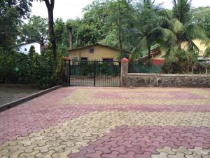 a driveway with a gate in front of a house at Lilly Vacation Homes - Alibaug in Kīhīm