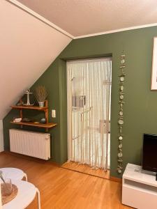 a living room with green walls and a sliding door at Seute Deern- Görtz in Fehmarn