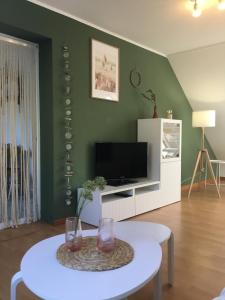 a living room with a table and a tv at Seute Deern- Görtz in Fehmarn +7 photos