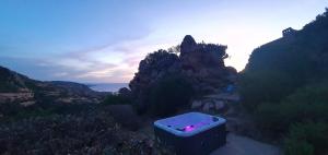 a bath tub sitting on the side of a mountain at Roccette OndaTURCHESE, Vista Mare e Jacuzzi Privata in Costa Paradiso