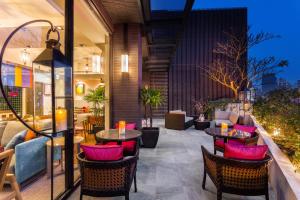 a patio with tables and chairs and a couch at Lacle Hotel-Luzhou Taipei in Taipei
