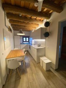 Una cocina con una mesa de madera y gabinetes blancos. en Barcelona Classic Palau Apartments, en Barcelona