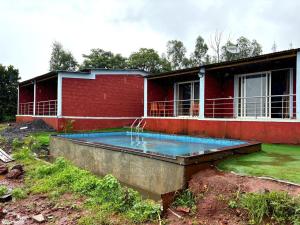 パンチガニにあるPanchgani agro tourismの正面にプールがある家