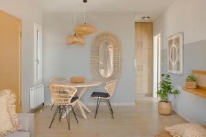 EFLにあるAlma Luxury Residences- Eos apartment 3のダイニングルーム(テーブル、椅子、鏡付)