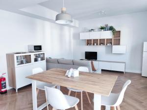 een keuken en woonkamer met een houten tafel en stoelen bij VILLAGGIO LIDO - Cavallino in Cavallino-Treporti