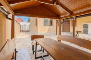 a patio with a wooden table and benches at Casa Bella in Oradea