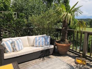 a white couch sitting on a balcony with a palm tree at Spa&Golf-Suite Velden in Velden am Wörthersee