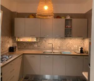 a kitchen with white cabinets and a sink at Casa Ambra in Specchiolla