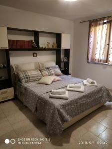 a bedroom with a large bed with two towels on it at Alma House - Affitti Brevi Italia in Porto Torres