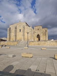 an old stone building with a large building at Hostal las Cantigas in Villalcázar de Sirga