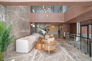 a lobby with a white couch and chairs at ZANA by the Ganges, Tapovan, Rishikesh in Rishīkesh