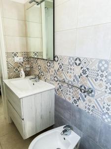 une salle de bain avec un lavabo et un miroir et des toilettes dans l'établissement APPARTAMENTO 5 POSTI - Puglia - Marina di Pescoluse, à Marina di Pescoluse