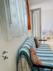 une chambre avec un lit avec une couverture et une fenêtre dans l'établissement APPARTAMENTO 5 POSTI - Puglia - Marina di Pescoluse, à Marina di Pescoluse 19 autres photos