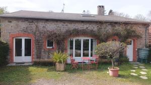 a brick house with a table and chairs in front of it at La maisonnette de Naomi in Coutances