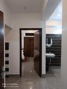a bathroom with a toilet and a sink in a room at Magadh Homestay in Patna +9 photos