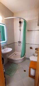 a bathroom with a green shower curtain and a tub at Vineyard Spa Resort 2-Room Apartement in Kableshkovo +19 photos