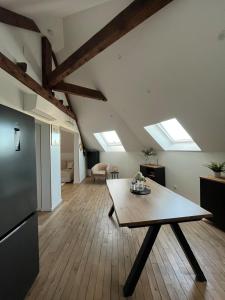 a living room with a table and some skylights at Appartement type T2 Il Giardino Sospeso in Le Creusot