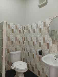 a bathroom with a toilet and a sink at MWELL House in Ban Klang