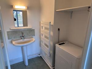 a bathroom with a sink and a washing machine at Appartement centre ville et terrasse in Brive-la-Gaillarde +33 photos