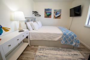 ein Schlafzimmer mit einem Bett und eine Kommode mit einer Lampe in der Unterkunft Double Take! Renovated Vacation Home in Panama City Beach