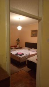 a bedroom with two beds and a door to a room at ,,Vruć Vetar,, in Majdanpek