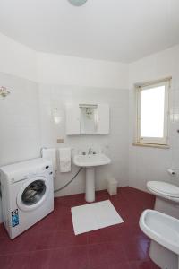 a white bathroom with a washing machine and a sink at villetta rosa blu marina di modica in Marina di Modica +27 photos