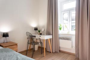 a bedroom with a desk and a bed and a window at Celje City Stay in Celje