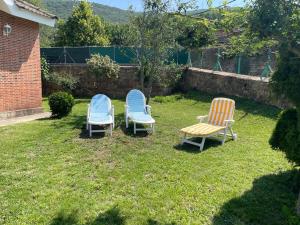 three chairs sitting in the grass in a yard at La torre in Barruelo de Santullán