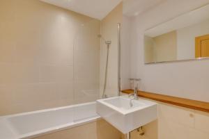 a white bathroom with a sink and a shower at Rosemary's - coastal cottage Seaton in Seaton +4 photos
