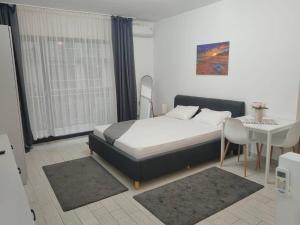 a bedroom with a bed and a table and a desk at Desilva Residences - Loft Club in Mamaia