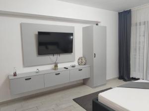 a white living room with a tv on a wall at Desilva Residences - Loft Club in Mamaia