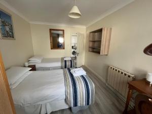 a hotel room with two beds and a table at The Coach House in Feevaghmore