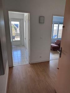 an empty living room with a door leading to a living room at Appartement centre ville et terrasse in Brive-la-Gaillarde