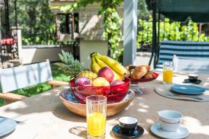 a table with a bowl of fruit on top of it at Le Chateau by CorfuΕscapes in Corfu
