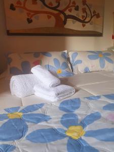 a bed with white towels and blue flowers on it at Sinis Apartment in Palmas Arborea