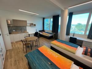 a room with two beds and a table and a kitchen at Motel Barka in Koper