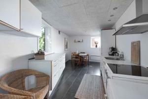 a kitchen with white cabinets and a sink at Holiday Apartment At Solgaarden 1 In Årsdale in Svaneke
