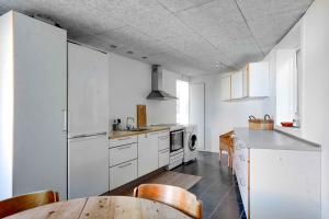 a kitchen with white appliances and a wooden table at Holiday Apartment At Solgaarden 1 In Årsdale in Svaneke +16 photos