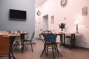 une salle à manger avec des chaises, une table et une télévision dans l'établissement La Baia Di Partenope, à Naples