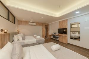 门格洛尔Hotel Shoolin Comforts的配有床和电视的酒店房间